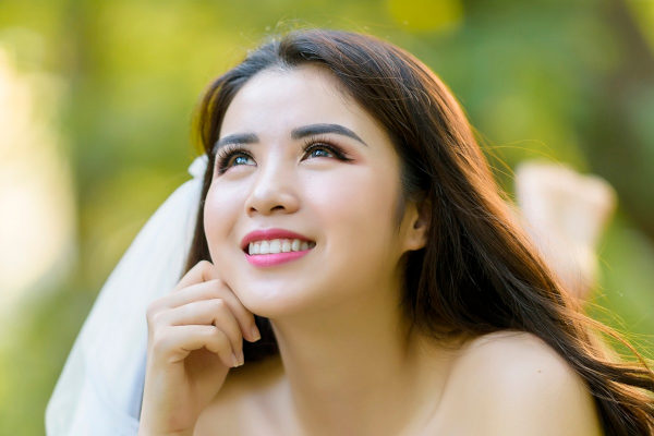 Glücklich lächelnde junge Frau mit perfekten Zähnen