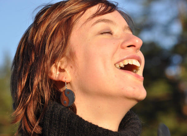 Eine Frau mit guten Zähnen hell lachend in dr Abendsonne
