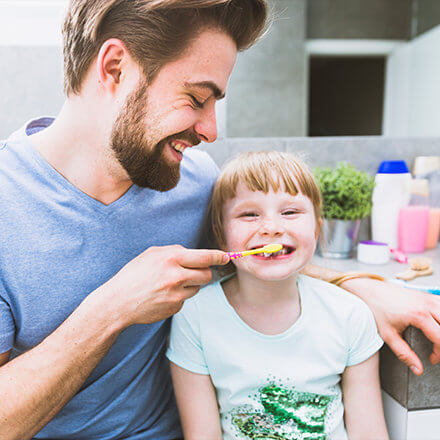 Vater bürstet seiner Tochter die Zähne